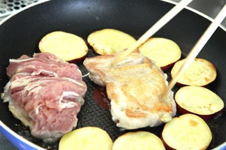 鶏肉とサツマイモの照り焼き（作り方１）＿＿フライパンに油を熱し、鶏肉は皮を下にして入れる。空いているところにサツマイモを並べ、中火でじっくりと焼く。