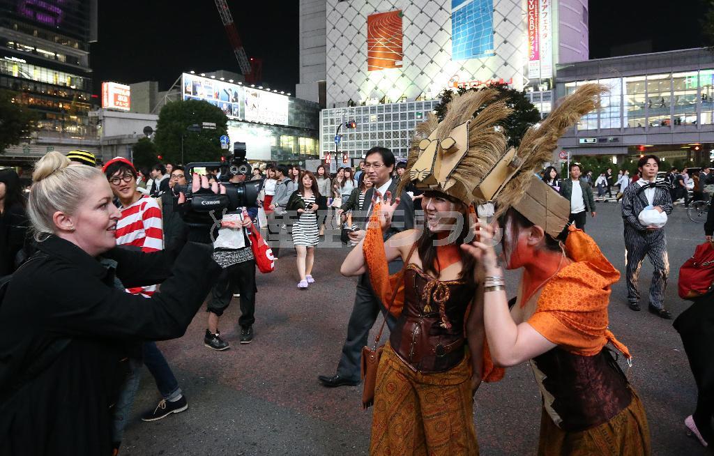 ハロウィーン前日、東京・渋谷のスクランブル交差点では仮装した人たちが街を歩き、外国人メディアや観光客らに囲まれていた＝２０１５年１０月３０日午後、東京都渋谷区（大西正純撮影）