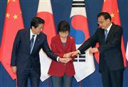 ３カ国首脳会談を前に、韓国の朴槿恵大統領（中央）に促され、安倍晋三首相（左）と中国の李克強首相の３人で手を重ねた＝１日、ソウルの青瓦台（ＡＰ）
