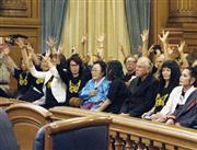 ９月２２日、米サンフランシスコ市議会で決議採択をほかの支持者らとともに喜ぶ李容洙氏（中央）＝共同