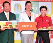 新メニュー「おてごろマック」を持つ店員らとサラ・カサノバ社長（中央）