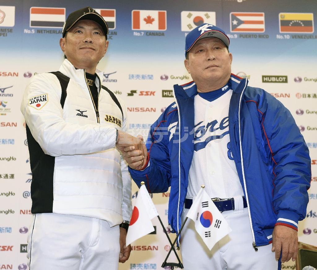 握手する日本代表の小久保裕紀（ひろき）監督（左）と韓国代表の金寅植監督＝２０１５年１１月７日、北海道札幌市内のホテル（共同）