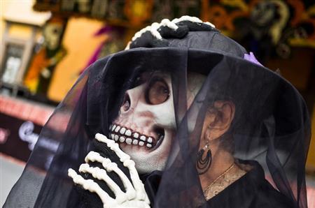 町はガイコツの仮装をした人たちであふれる。なかなかリアリティあるガイコツの仮面を付けた女性＝２０１５年１０月３１日、メキシコ・首都メキシコ市（ＡＰ）