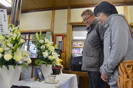 ＪＲ幾寅駅（いくとらえき）の駅舎内にある高倉健（けん）さんの遺影を見る観光客＝２０１５年１１月６日、北海道空知郡南富良野町（共同）