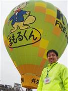 共栄火災海上保険の熱気球「まもるくん号」と熱気球パイロットを目指す宮本泰弘さん＝１０月３１日、佐賀市嘉瀬川河川敷