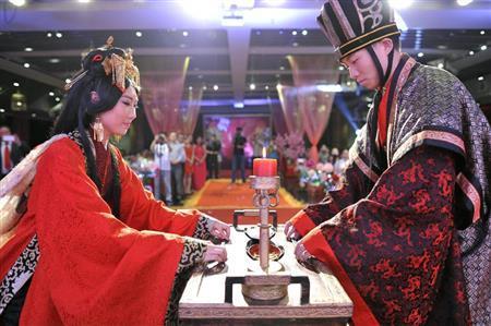 古代の儀式にのっとって執り行われた結婚式で、特注の漢服に身を包んだ王叡舒さん（左）と潘浩源さん＝２０１５年７月、中国・首都北京市（共同）