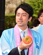 和歌山ふるさと市場の開会式で、柿を手に記念撮影に応じる小泉進次郎農林部会長＝１２日午前、東京・永田町の自民党本部（斎藤良雄撮影）