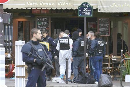 同時多発テロから一夜明け、銃撃があったカフェを調べる警察官＝２０１５年１１月１４日、フランス・首都パリ（ロイター＝共同）