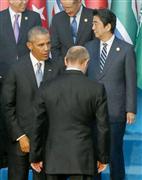 Ｇ２０首脳会合の記念撮影に臨む際、あいさつを交わすオバマ米大統領（左）とロシアのプーチン大統領（中央）。右は安倍首相＝１５日、トルコ・アンタルヤ（共同）