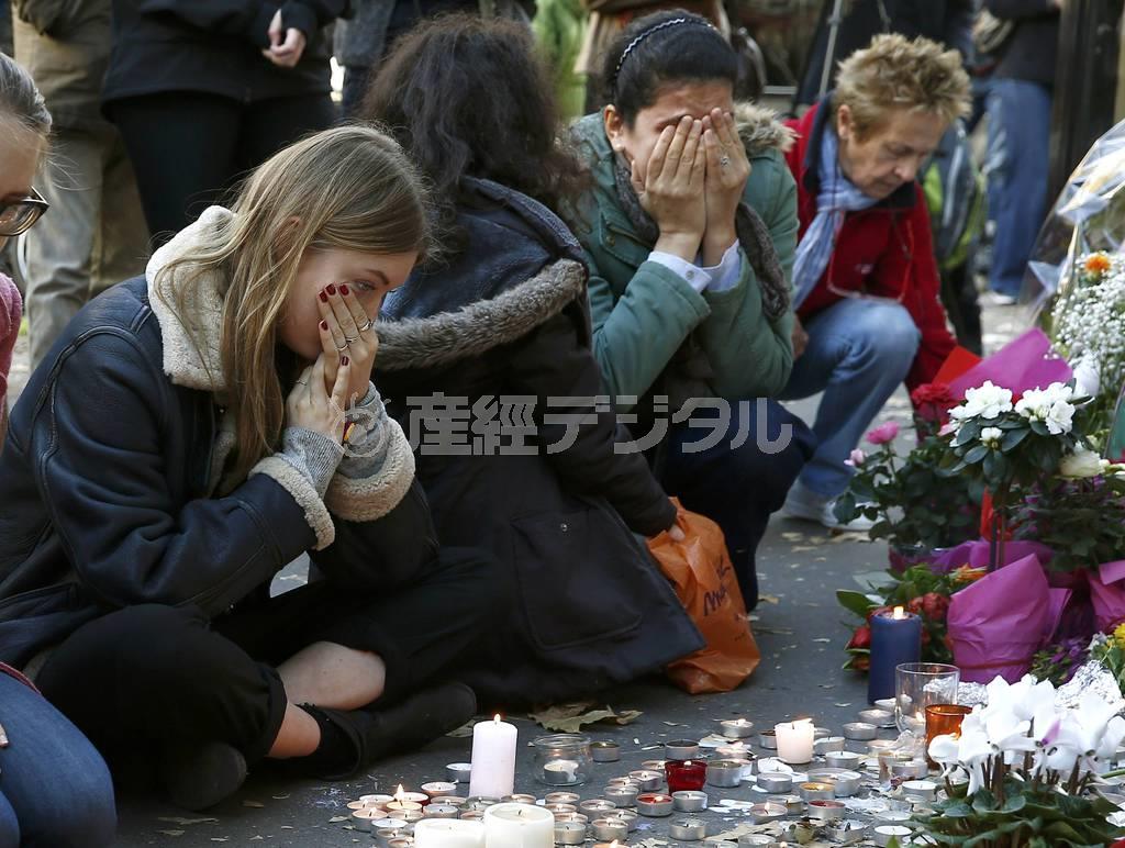 日曜日を迎えたパリで、同時多発テロの襲撃現場にろうそくや花をささげ、泣き崩れる女性ら＝２０１５年１１月１５日、フランス・首都パリ（ロイター）