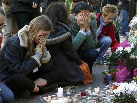 日曜日を迎えたパリで、同時多発テロの襲撃現場にろうそくや花をささげ、泣き崩れる女性ら＝２０１５年１１月１５日、フランス・首都パリ（ロイター）