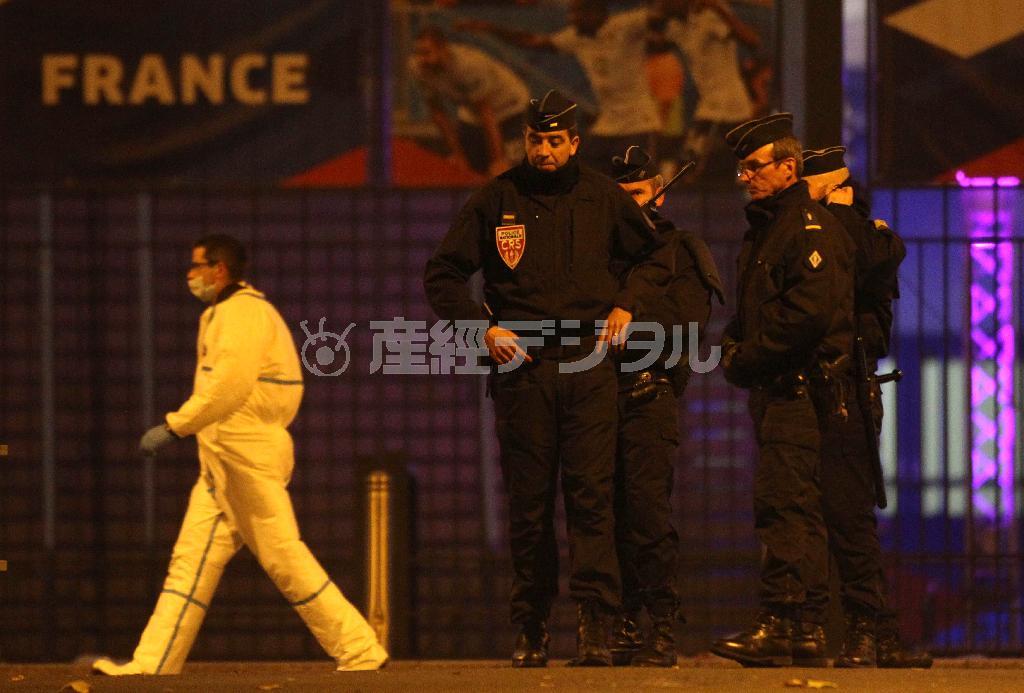 スタジアムの外では警官が沈痛な表情でうなだれていた＝２０１５年１１月１３日、フランス・サンドニ（ＡＰ）