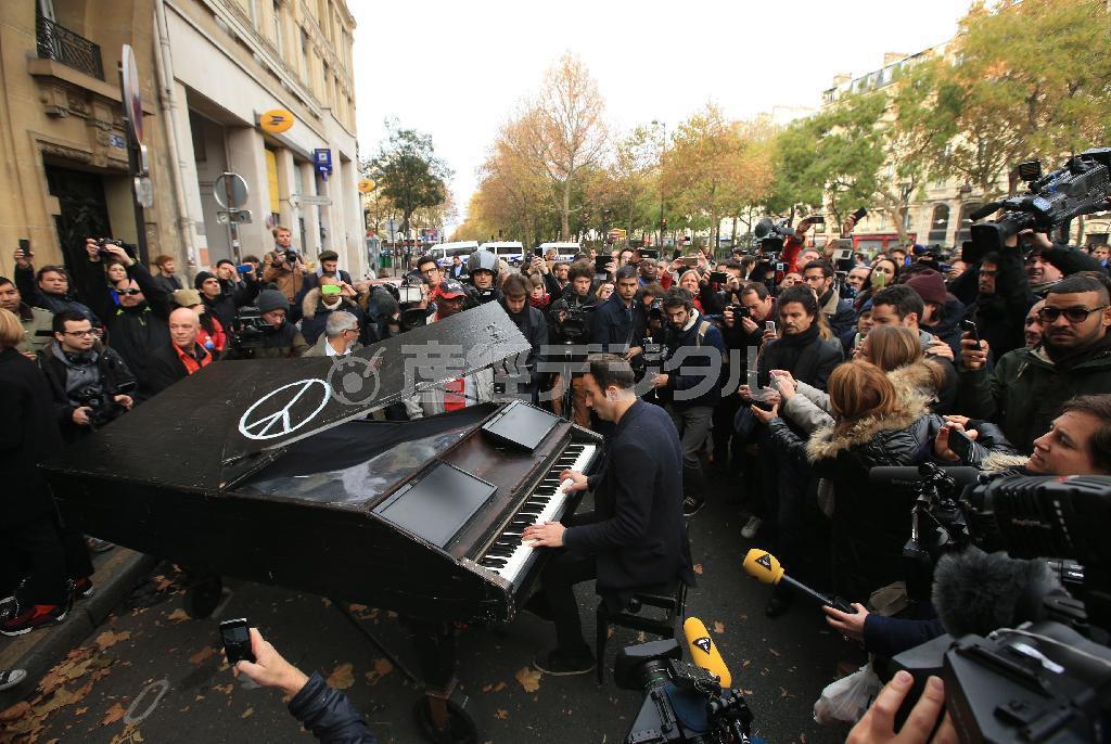 パリ同時テロから一夜明けた１１月１４日、バタクラン劇場の前ではジョン・レノンの「イマジン」を歌い、大勢の犠牲者を悼むとともに、平和を求める人の姿がみられた＝２０１５年、フランス・首都パリ（ＡＰ）