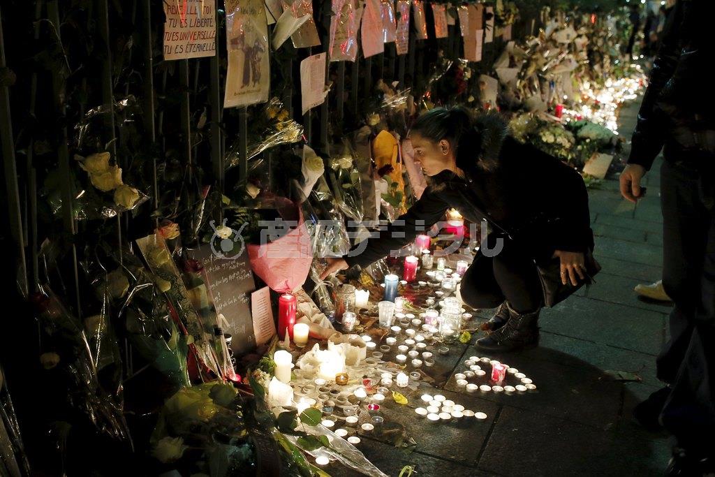 １１月１８日夜、同時多発テロで８９人の犠牲者が出たパリのバタクラン劇場前では、多くのキャンドルがともされ、花を手向ける人が絶えなかった＝２０１５年、フランス・首都パリ郊外ドランシー（ロイター）
