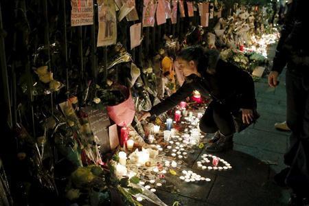 １１月１８日夜、同時多発テロで８９人の犠牲者が出たパリのバタクラン劇場前では、多くのキャンドルがともされ、花を手向ける人が絶えなかった＝２０１５年、フランス・首都パリ郊外ドランシー（ロイター）