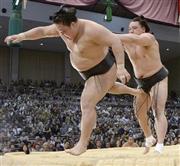 日馬富士（はるまふじ、右）が押し出しで豪栄道を下す＝２０１６年５月１７日、福岡県福岡市博多区の福岡国際センター（共同）