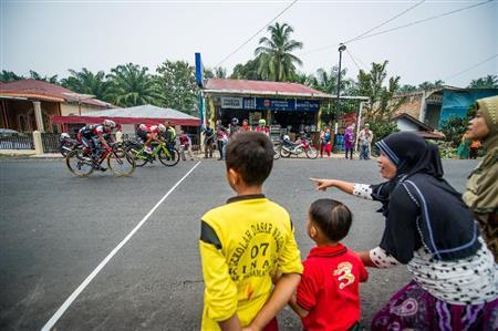 中間スプリントラインで観戦する地元の人たち。自転車ロードレースは生活道路がレースコースとなり、誰もが無料で観戦できるスポーツ＝２０１５年１０月初旬、インドネシア・西スマトラ州（田中苑子さん撮影）