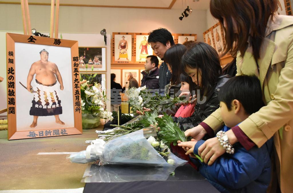 「横綱北の湖記念館」に設置された献花台に花を手向ける地元の人たち＝２０１５年１１月２１日午前、北海道有珠郡壮瞥町（共同）