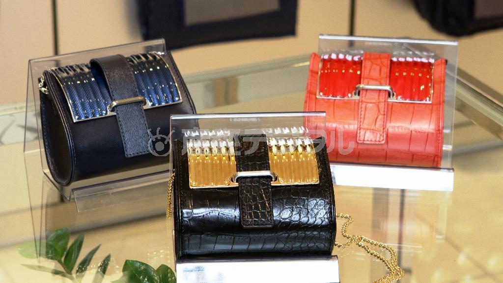 トマト缶などの、缶詰の空き缶を再利用したバッグ。革の部分もデッドストックなど使われずに廃棄される運命の素材を利用した（３点各６万４８０円）＝２０１５年１０月２２日、神奈川県横浜市西区の横浜高島屋（田中幸美撮影）