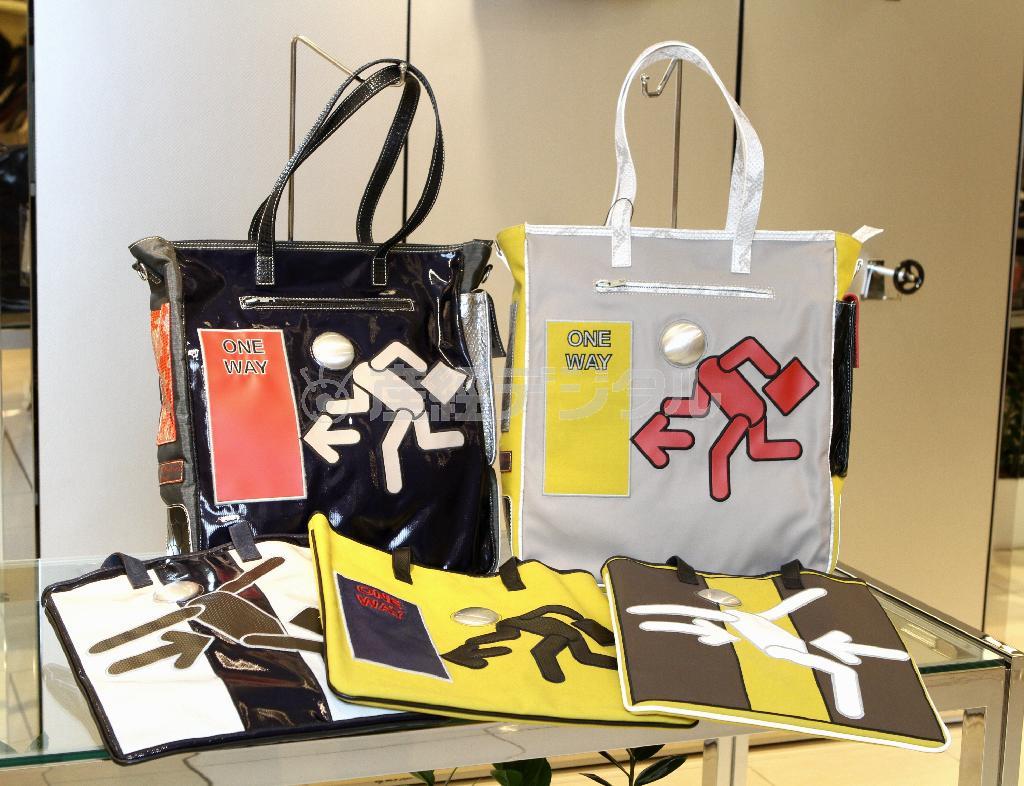 言語が異なっても意味が通じる絵文字「ピクトグラム」をデザインしたユニークなバッグ。顔の部分にジュースの缶の底の部分を使用してポップに仕上げた立てかけられた黒と白のバッグ各１５万１２００円、手前の３点各５万１８４０円＝２０１５年１０月２２日、神奈川県横浜市西区の横浜高島屋（田中幸美撮影）