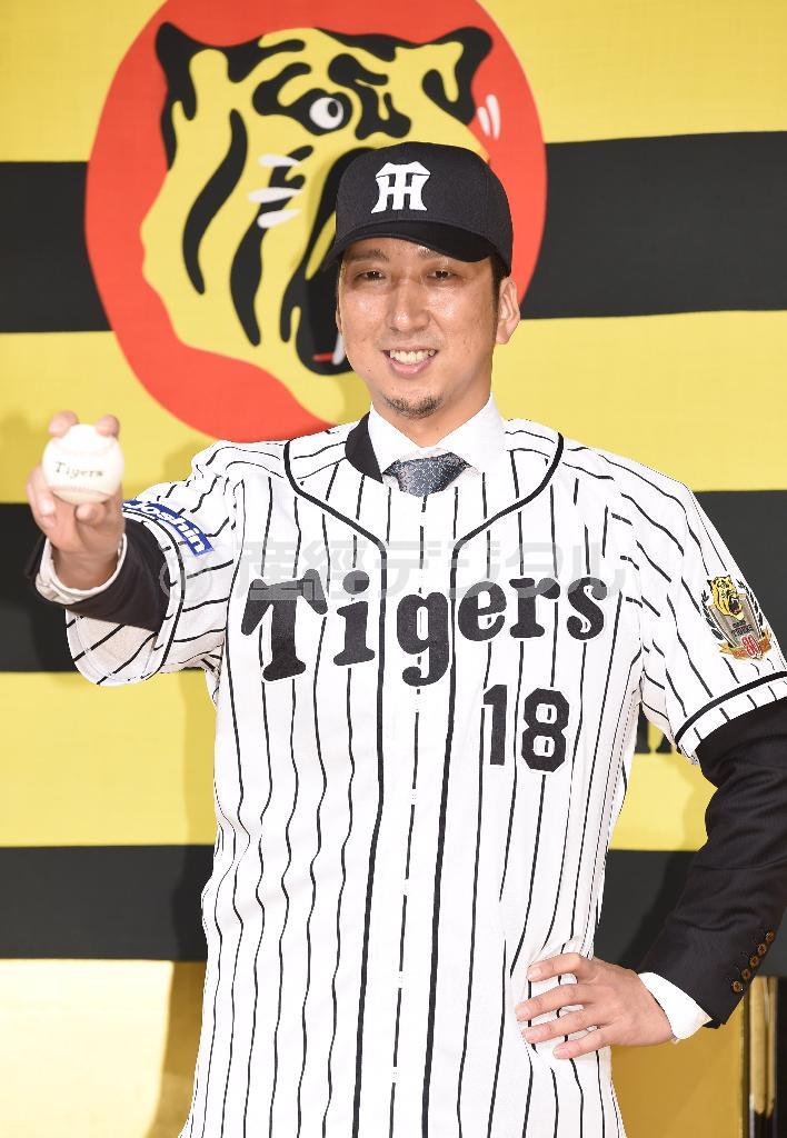 ４季ぶりに縦縞のユニホームに袖を通し、ポーズを取る藤川球児（きゅうじ）＝２０１５年１１月２４日、大阪市北区（甘利慈撮影）