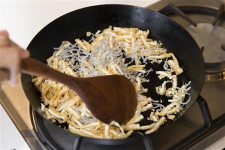 油揚げとじゃこをカリカリに炒めて食感を演出する（松下二郎さん撮影）