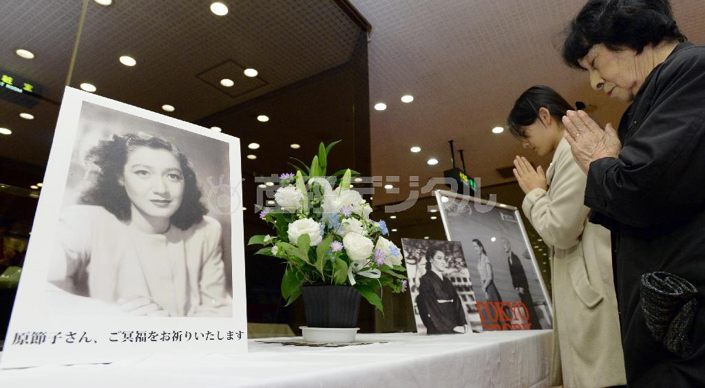 東京・築地の東劇内に設置された“伝説の女優”原節子さんの献花台の前で手を合わせる女性ファンら＝２０１５年１１月２６日午後、東京都中央区（寺河内美奈撮影）