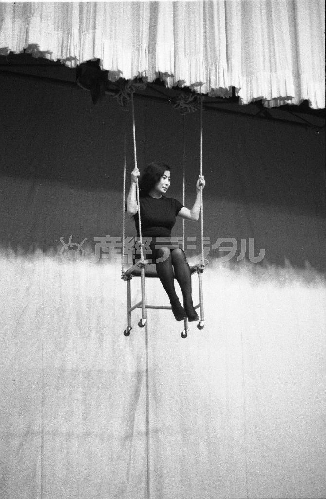 オノ・ヨーコ《チェア・ピース》１９６２年、「ジョン・ケージとデヴィッド・チュードアのイヴェント」（京都会館、１９６２年１０月１２日）で行う（吉岡康弘さん撮影、個人蔵）。Ｃｏｕｒｔｅｓｙ＿ｏｆ＿Ｌｅｎｏｎｏ＿Ｐｈｏｔｏ＿Ａｒｃｈｉｖｅ。（Ｃ）ＹＯＫＯ＿ＯＮＯ＿２０１５