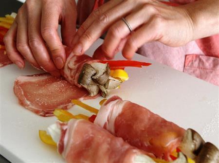 エリンギの肉巻き（作り方）＿＿豚肉を広げて小麦粉をふり、エリンギ、パプリカをのせて巻く（田中幸美撮影）