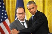 １１月２４日、ホワイトハウスでの記者会見で、フランスのフランソワ・オランド大統領（左）を抱きしめるバラク・オバマ米大統領。両首脳は「イスラム国」への空爆拡大で合意したが、会談をリードしたのはオランド氏で、オバマ氏はどこまでも受け身だった＝２０１５年、米国・首都ワシントン（ＵＰＩ＝共同）