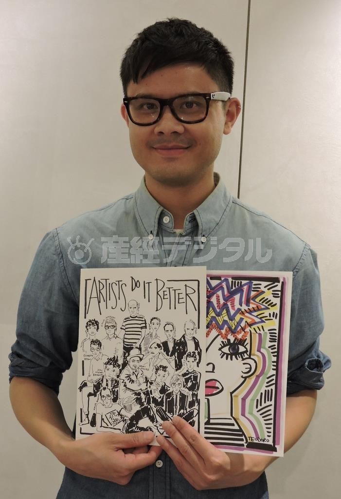 自作のイラストを持つジャスティン・テオドロさん＝２０１５年１１月１２日、東京都新宿区（藤沢志穂子撮影）