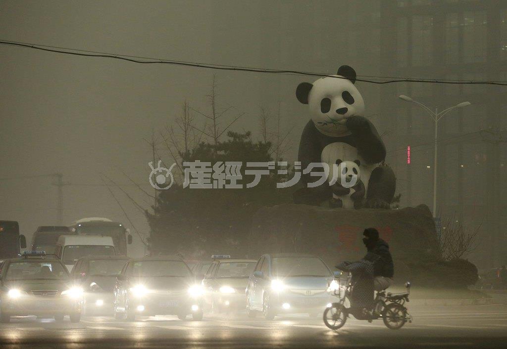 大気汚染で夜のように暗くなった首都北京市街。パンダの銅像もかすみ、車はライトを点灯して走行した＝２０１５年１２月１日、中国（ロイター）