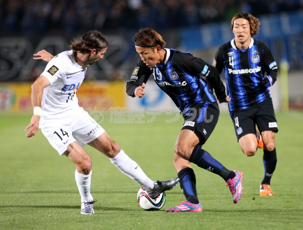 前半、広島・ミキッチと競り合うＧ大阪・宇佐美貴史（中）＝２０１５年１２月２日、大阪府吹田市の万博記念競技場（永田直也撮影）