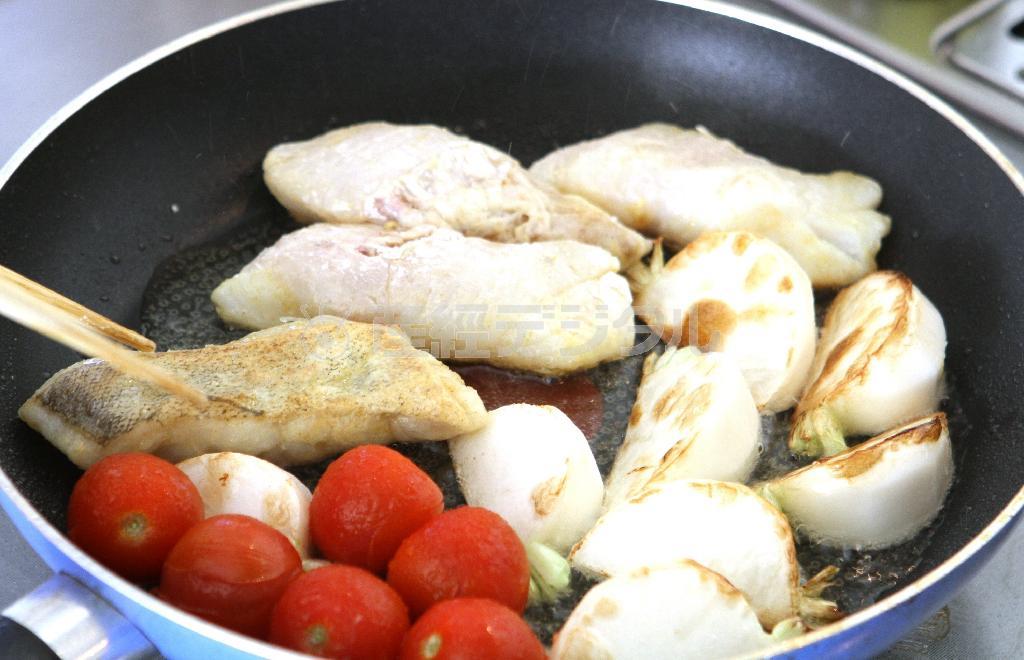 タラとカブのカレームニエル（作り方３）＿＿フライパンにオリーブ油を熱し、（作り方２：調理したタラ）および、カブ、トマトを入れて、両面を香ばしく焼く。