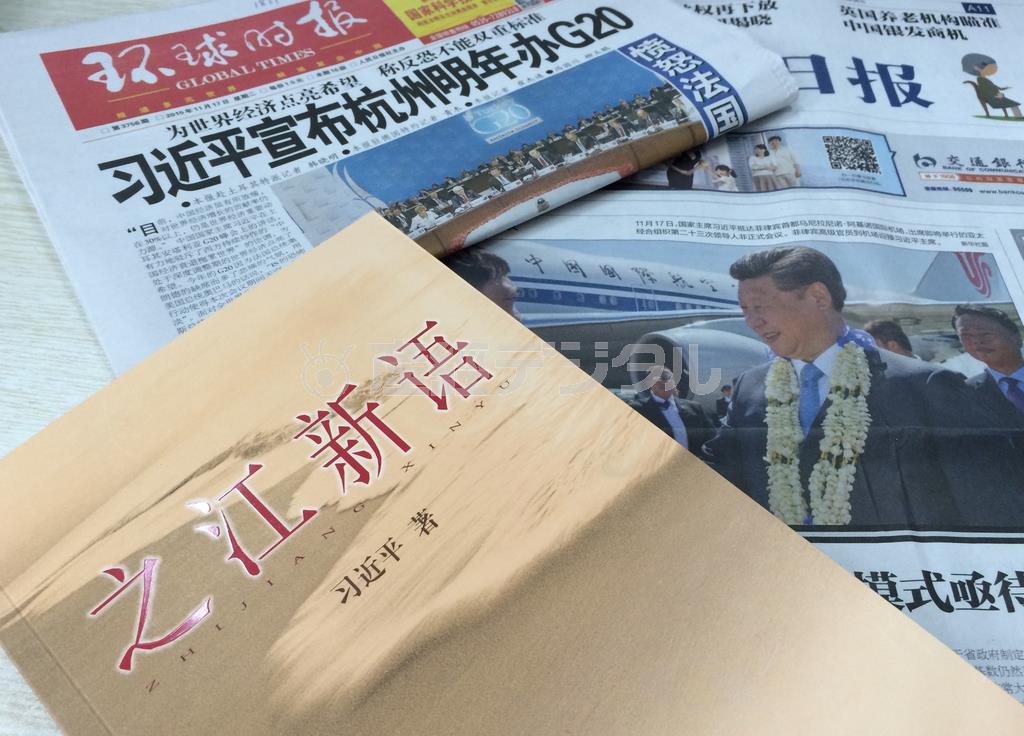 習近平国家主席（党総書記）が浙江省トップの党委書記などを務めた２００３～０７年に地元紙、浙江日報に寄稿したコラムから２３２本を選んだ書籍「之江新語」と、中国が初めてホスト国となる来年の２０カ国・地域（Ｇ２０）首脳会議の開催地を浙江省杭州に決めたことなどを伝える中国紙＝２０１５年１２月１日（河崎真澄撮影）