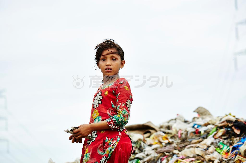 ゴミ山で立ち尽くすモスミ＝２０１５年７月２９日、バングラデシュ・首都ダッカ（ワールド・ビジョン・ジャパン撮影）