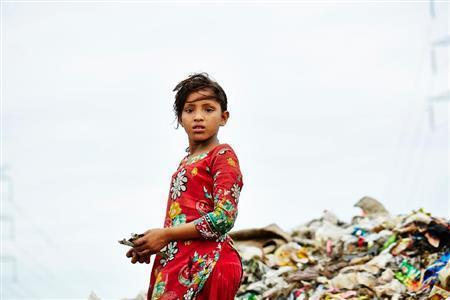 ゴミ山で立ち尽くすモスミ＝２０１５年７月２９日、バングラデシュ・首都ダッカ（ワールド・ビジョン・ジャパン撮影）