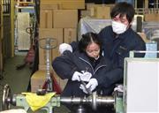 職人の手ほどきを受けて、金属加工技術の「へら絞り」を体験する女の子＝東京都大田区