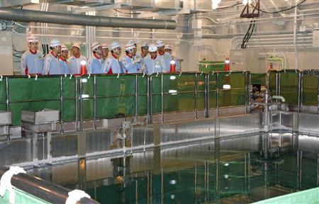 四国電力伊方原発３号機の原子炉建屋内の使用済み核燃料プールを視察する林経産相（奥・前列右から２人目）＝２１日午前、愛媛県伊方町（代表撮影）