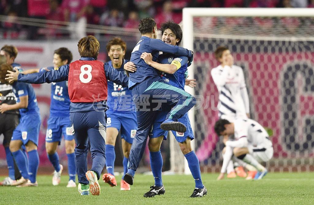 Ｊ１昇格を決め、抱き合って喜ぶ城後寿（じょうご・ひさし、中央右）ら福岡イレブン＝２０１５年１２月６日、大阪府大阪市東住吉区のヤンマースタジアム長居（共同）