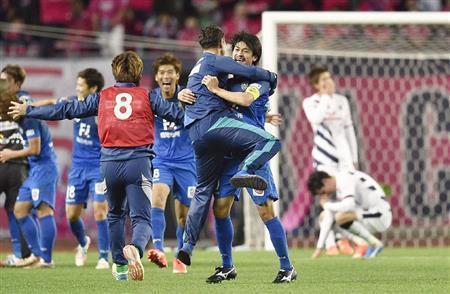 Ｊ１昇格を決め、抱き合って喜ぶ城後寿（じょうご・ひさし、中央右）ら福岡イレブン＝２０１５年１２月６日、大阪府大阪市東住吉区のヤンマースタジアム長居（共同）
