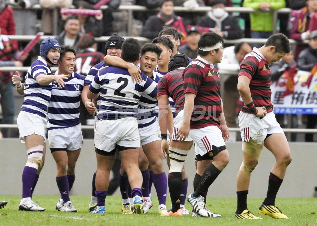３年ぶり１６度目の優勝を果たし、抱き合って喜ぶ明大フィフティーン。右端は肩を落とす早大・藤田慶和（よしかず）＝２０１５年１２月６日、東京都港区の秩父宮ラグビー場（共同）