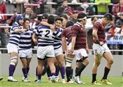 ３年ぶり１６度目の優勝を果たし、抱き合って喜ぶ明大フィフティーン。右端は肩を落とす早大・藤田慶和（よしかず）＝２０１５年１２月６日、東京都港区の秩父宮ラグビー場（共同）