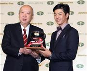 ＭＩＰ賞を獲得し、日本ゴルフツアー機構（ＪＧＴＯ）の海老沢勝二会長（左）からトロフィーを受け取る石川遼＝２０１５年１２月７日、東京都内のホテル（共同）