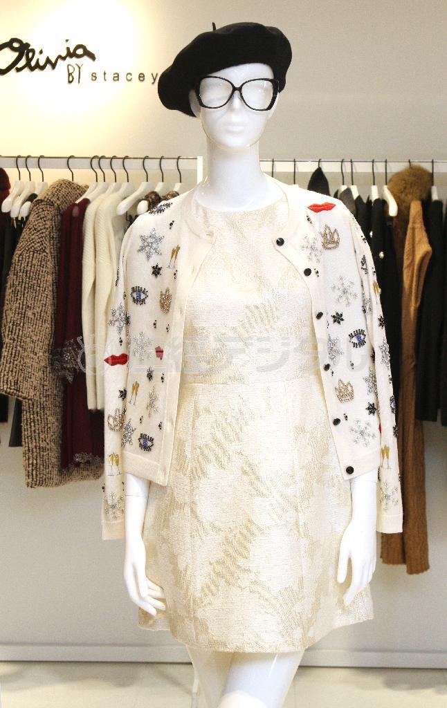 アリスアンドオリビアからはオフホワイトのジャカード織りワンピース（５万６０００円）。花のような模様が浮き上がって見える。カーディガン（８万５０００円）はシャンパンやリップ、雪をかたどったビジューが敷き詰められ、ゴージャス感満載＝２０１５年１１月２６日、東京都中央区銀座（荻窪佳撮影）