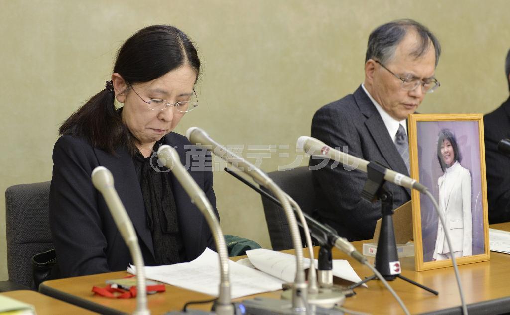 過労自殺訴訟の和解を受けた記者会見で、うつむく自殺した森美菜さんの母、祐子さん（左）と父、豪さん＝２０１５年１２月８日午後、厚労省（共同）