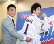 マリナーズの青木宣親（のりちか）外野手（左）からユニホームを手渡されるヤクルト・山田哲人（てつと）＝２０１５年１２月８日、東京都港区（大橋純人撮影）