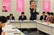 公明党税制調査会総会などの合同会議で、税制改正大綱案の資料を手にあいさつする斉藤鉄夫税調会長（奥左から３人目）＝１０日午後、東京・永田町の衆院第二議員会館（斎藤良雄撮影）