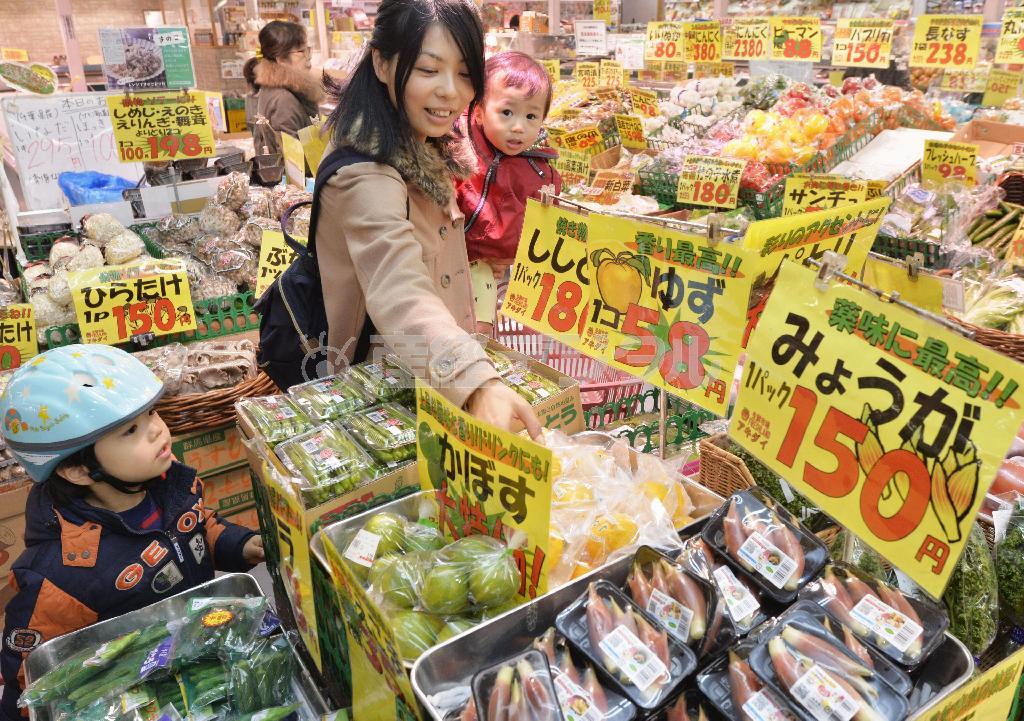 生鮮品売り場で買い物をする親子連れ。消費税の税率が２つ併存することになり、消費者からは「分かりづらい」「食品だけでは負担は軽くならない」といった声が漏れている＝２０１５年１２月１０日夕、東京都練馬区（共同）
