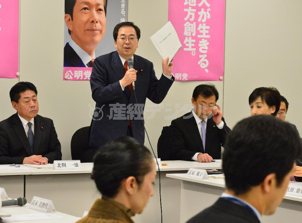 公明党税制調査会総会などの合同会議で、税制改正大綱案の資料を手にあいさつする斉藤鉄夫税調会長（奥左から２人目）。来夏の参院選を控え、軽減税率でひとまず自民党から譲歩を引き出した形だ＝２０１５年１２月１０日午後、東京都千代田区永田町の衆院第二議員会館（斎藤良雄撮影）